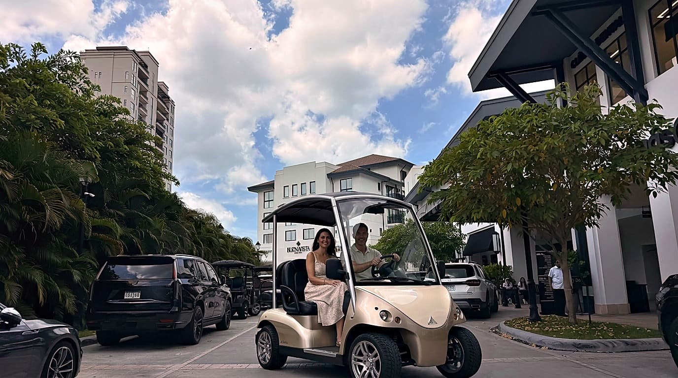 Couple in a golf cart at the Santa María Golf & Country Club retail plaza, Panama